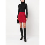 Model wearing Wolford Top Black, long sleeve roll neck bodysuit, paired with a red skirt, black boots, holding a small black clutch.